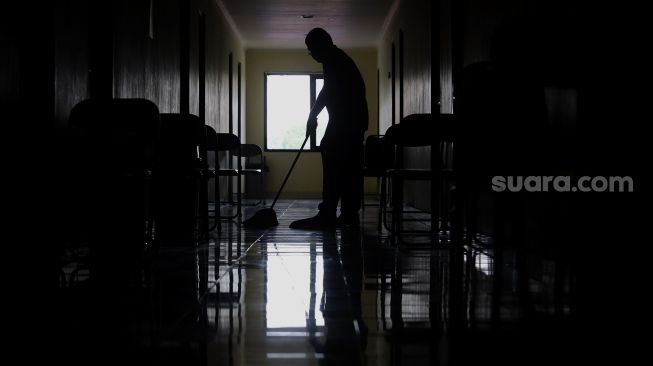 Petugas membersihkan area lorong di Graha Wisata Ragunan, Jakarta, Rabu (30/9/2020). [Suara.com/Angga Budhiyanto]