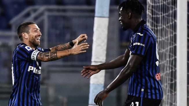 Second striker Atalanta, Alejandro Papu Gomez merayakan golnya bersama penyerang Duvan Zapata pada laga Liga Italia 2020/2021 kontra Lazio di Stadio Olimpico, Roma, Kamis (1/10/2020) dini hari WIB. [Filippo MONTEFORTE / AFP]