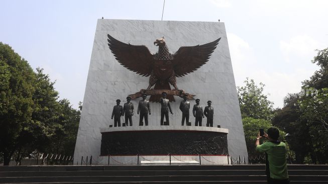 Petugas Dinas Kehutanan memotret Monumen Pancasila Sakti di Lubang Buaya, Jakarta, Kamis (1/10/2020). [Suara.com/Angga Budhiyanto]