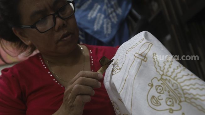 Perajin menyelesaikan proses pembuatan motif batik di Rumah Batik Palbatu, Jakarta Selatan, Kamis (1/10/2020). [Suara.com/Angga Budhiyanto]