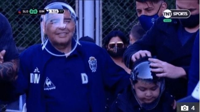 Diego Maradona dengan masker uniknya dalam pertandingan uji coba Gimnasia vs San Lorenzo. (Dok. TNT Sports).