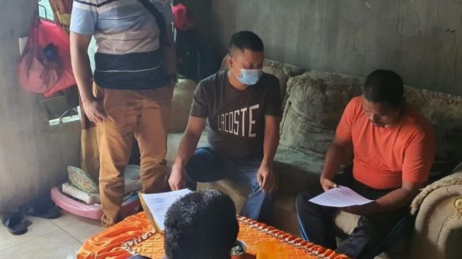 Sulaiman Marpaung (baju oranye) pelaku pengunggah foto Wapres Maruf Amin dengan bintang porno jepang ketika ditangkap aparat polisi. (istimewa)