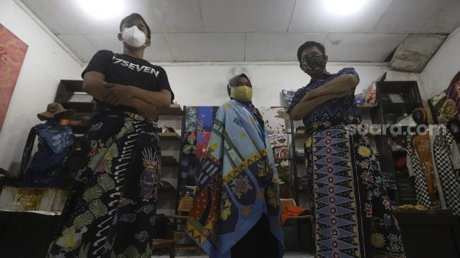 Perajin menggunakan batik buatannya berpose di Rumah Batik Palbatu, Jakarta, Jumat (2/10/2020). [Suara.com/Angga Budhiyanto]