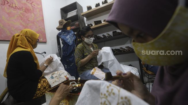 Perajin menyelesaikan proses pembuatan motif batik di Rumah Batik Palbatu, Jakarta, Jumat (2/10/2020). [Suara.com/Angga Budhiyanto]