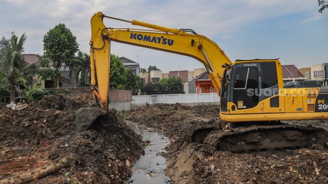 Alat berat digunakan untuk mengeruk material tanah dalam proses pembangunan Waduk Pilar Jati di Cipinang Melayu, Jakarta Timur,  Sabtu (3/10). [Suara.com/Alfian Winanto]