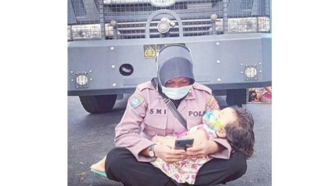 Viral Foto Polwan Jaga Kantor Bawaslu Sambil Mengasuh Anaknya