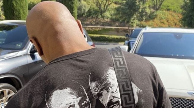 Kaos atau t-shirt dengan punggung bertuliskan jadwal balapan. Simak Rolls-Royce di sisi kanannya [Instagram: miketyson].