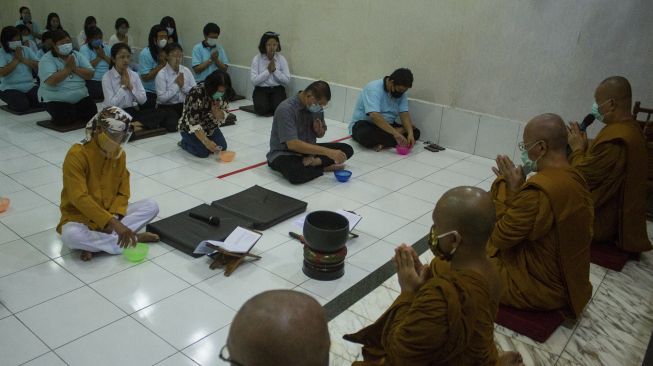 Sejumlah umat buddha melakukan pelimpahan jasa kepada bhikkhu saat prosesi Sanghadana Kathina atau mengumpulkan persembahan dari umat di Wihara Buddha Dhamma, Karawang, Jawa Barat, Sabtu (3/10/2020). [ANTARA FOTO/M Ibnu Chazar]