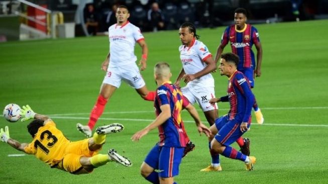 Pemain Barcelona Philippe Coutinho menjebol gawang Sevilla dalam pertandingan di Camp Nou, Senin (5/10/2020). [AFP]