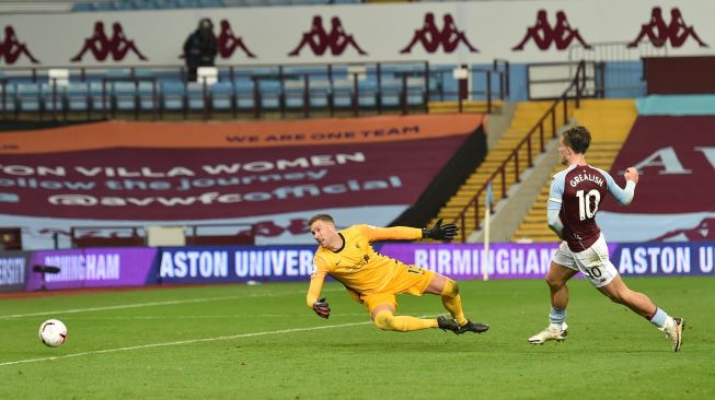 Gelandang Aston Villa Jack Grealish (tengah) mencetak gol ketujuh mereka usai melewati kiper Liverpool Adrian selama pertandingan sepak bola Liga Premier Inggris antara Aston Villa melawan Liverpool di Villa Park, Birmingham, Inggris, Senin (5/10) dini hari WIB. [Catherine Ivill / POOL / AFP]
