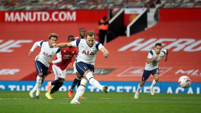 Striker Tottenham Hotspur Harry Kane mencetak gol melalui penalti untuk gol keenam selama selama pertandingan sepak bola Liga Premier Inggris antara Manchester United melawan Tottenham Hotspur di Old Trafford, Manchester, Inggris, Minggu (4/10). [CARL RECINE / AFP]