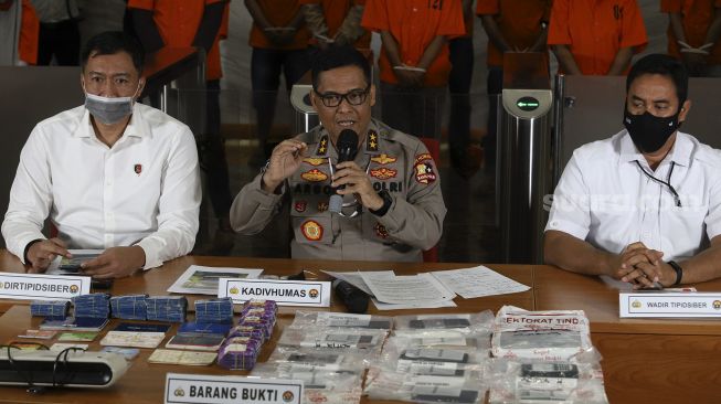 Kadiv Humas Polri Irjen Argo Yuwono (tengah) memberikan keterangan kepada wartawan saat menggelar konferensi pers terkait kasus pembobolan perbankan di Bareskrim Polri, Jakarta, Senin (5/10/2020). [Suara.com/Angga Budhiyanto]