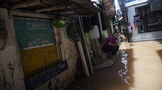 Warga menunggu air surut saat banjir melanda kawasan permukiman di Petogogan, Kebayoran Baru, Jakarta Selatan, Senin (5/10/2020). [ANTARA FOTO/Sigid Kurniawan]
