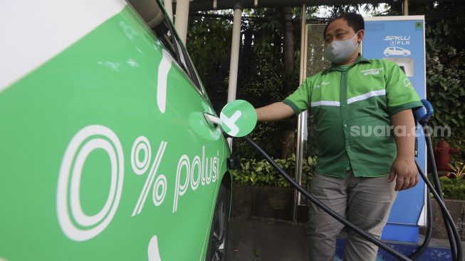 Pengemudi taksi online melakukan pengisian daya pada mobil listrik di Stasiun Pengisian Kendaraan Listrik Umum (SPKLU) di Kantor PLN Disjaya, Gambir, Jakarta, Selasa (6/10/2020). [Suara.com/Angga Budhiyanto]