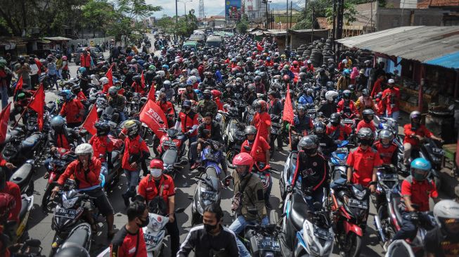 Ratusan buruh memblokir jalan nasional Bandung-Garut--Tasikmalaya saat melakukan aksi di Rancaekek, Kabupaten Bandung, Jawa Barat, Selasa (6/10/2020). Aksi tersebut merupakan buntut dari penolakan buruh terhadap pengesahan UU Cipta Kerja yang telah disahkan oleh DPR. [ANTARA FOTO/Raisan Al Farisi]