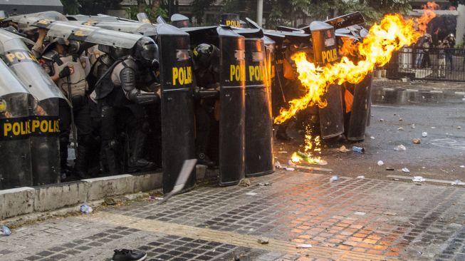 Personil Kepolisian menahan lemparan molotov oleh demonstran saat unjuk rasa tolak Undang-Undang Cipta Kerja di Depan Gedung DPRD Jawa Barat, Bandung, Jawa Barat, Rabu (7/10/2020).  [ANTARA FOTO]