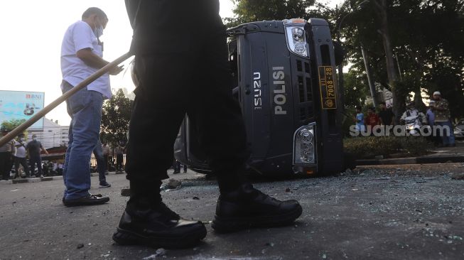 Mobil polisi yang dihancurkan oleh sejumlah massa aksi di kawasan Penjernihan, Jakarta, Rabu (7/10/2020). [Suara.com/Angga Budhiyanto]