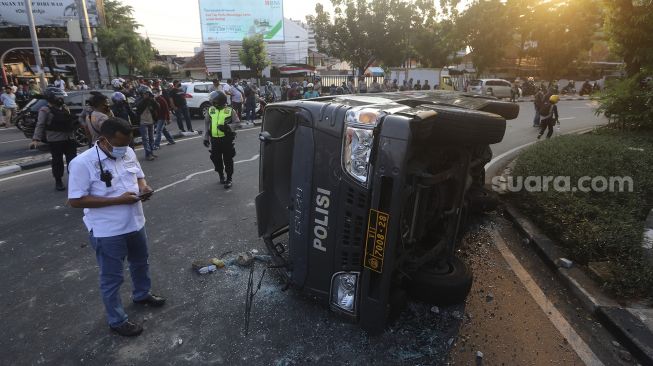 Mobil polisi yang dihancurkan oleh sejumlah massa aksi di kawasan Penjernihan, Jakarta, Rabu (7/10/2020). [Suara.com/Angga Budhiyanto]