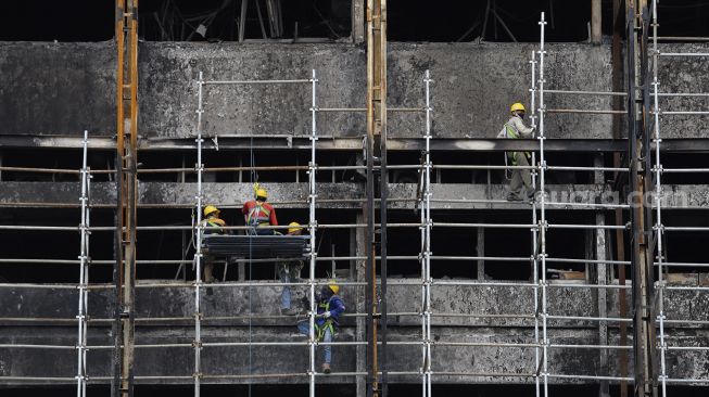 Pekerja memasang stager untuk perbaikan Gedung Kejaksaan Agung, Jakarta, Rabu (7/10/2020). [Suara.com/Angga Budhiyanto]