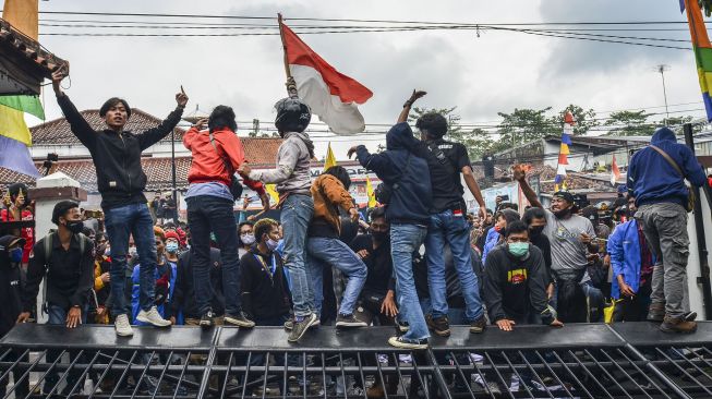 Massa dari aktivis mahasiswa, buruh dan masyarakat mendobrak pintu gedung dewan saat aksi unjuk rasa di Kantor DPRD Kota Tasikmalaya, Jawa Barat, Rabu (7/10/2020). [ANTARA FOTO]
