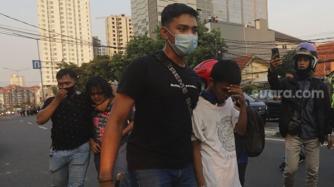 Aparat kepolisian menangkap dua massa yang terlibat bentrokan di kawasan Penjernihan, Jakarta, Rabu (7/10/2020). [Suara.com/Angga Budhiyanto]