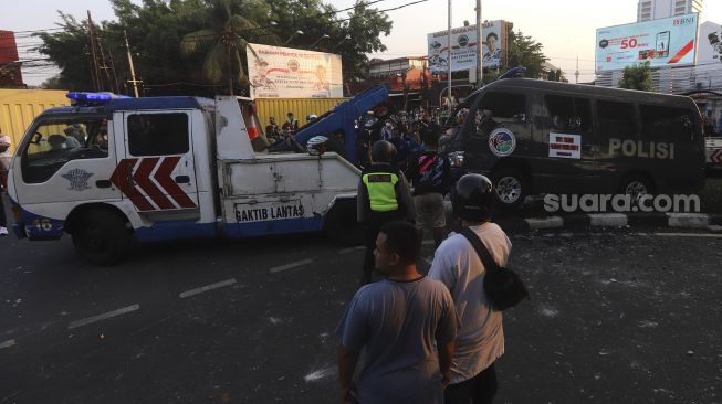 Mobil polisi yang dihancurkan oleh sejumlah massa aksi di kawasan Penjernihan, Jakarta, Rabu (7/10/2020). [Suara.com/Angga Budhiyanto]