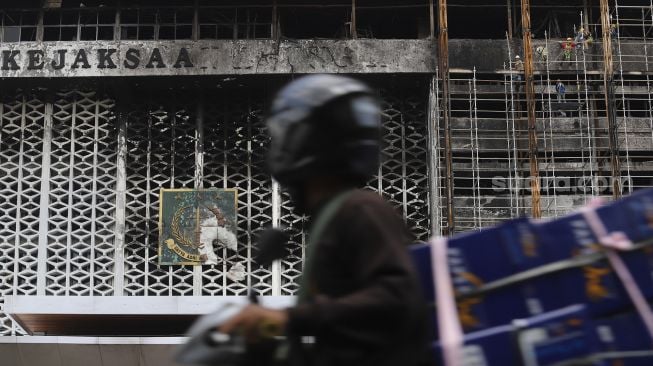 Pengendara sepeda motor melintas di depan Gedung Kejaksaan Agung, Jakarta yang tengah diperbaiki, Rabu (7/10/2020). [Suara.com/Angga Budhiyanto]