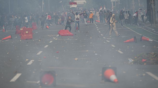 Pengunjuk rasa yang menolak pengesahan Undang-Undang Cipta Kerja menaiki patung pahlawan MH. Thamrin di Jalan Medan Merdeka Selatan, Jakarta, Kamis (8/10/2020). [ANTARA FOTO/Aditya Pradana Putra]