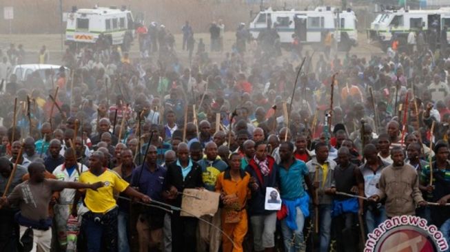 Ribuan pekerja tambang di Afrika Selatan mengikuti aksi di mogok di dekat lokasi tambang . (REUTERS/Mike Hutchings)