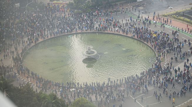 Pengunjuk rasa yang menolak pengesahan Undang-Undang Cipta Kerja menaiki patung pahlawan MH. Thamrin di Jalan Medan Merdeka Selatan, Jakarta, Kamis (8/10/2020). [ANTARA FOTO/Aditya Pradana Putra]