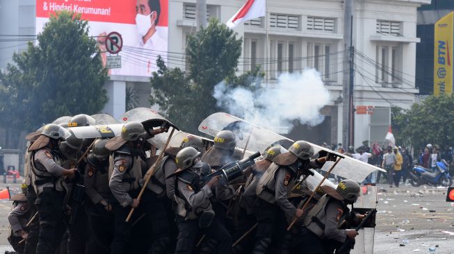 Polisi menembakkan gas air mata untuk membubarkan pengunjuk rasa yang menolah pengesahan Omnibus Law RUU Cipta Kerja di kawasan Harmoni, Jakarta, Kamis (8/10/2020).  Demonstrasi tersebut berakhir ricuh. [ANTARA FOTO/Indrianto Eko Suwarso]
