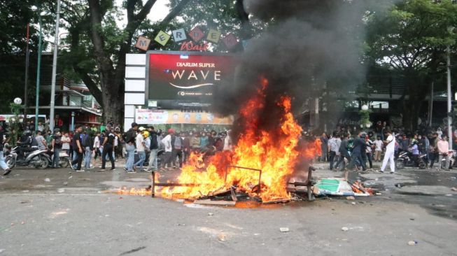 Massa melakukan aksi bakar di depan Merdeka Walk. [Foto: Istimewa]