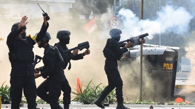 Polisi menembakkan gas air mata untuk membubarkan pengunjuk rasa yang menolah pengesahan Omnibus Law RUU Cipta Kerja di kawasan Harmoni, Jakarta, Kamis (8/10/2020).  Demonstrasi tersebut berakhir ricuh. [ANTARA FOTO/Indrianto Eko Suwarso]