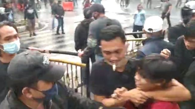 Sekelompok orang berbaju preman menangkap dan memukuli massa aksi penolak UU Cipta Kerja di Gedung DPRD Jawa Barat, Kamis (8/10/2020)