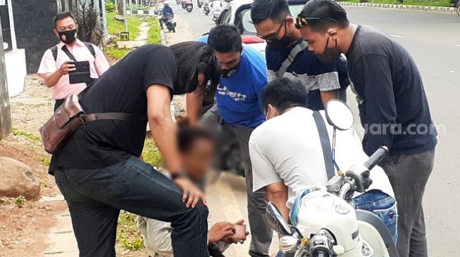 Salah satu peserta aksi tolak UU Cipta Kerja diamankan oleh aparat berbaju preman di depan gedung DPRD Tangsel, Kamis (8/10/2020). [Suara.com/Wivy Hikmatullah]