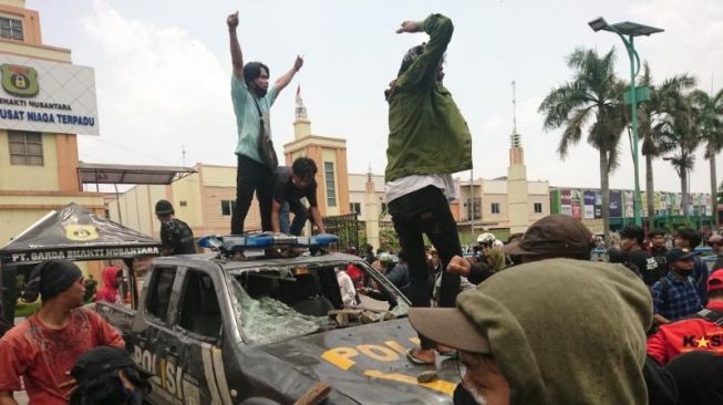 Massa merusak mobil Polisi di Jalan Daan Mogot, Jakarta Barat, Kamis (8/10). [Suara.com/ Irfan Maulana]
