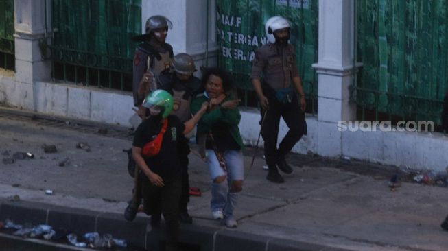 Seorang demonstran diciduk petugas saat demonstrasi menolak disahkannya Undang-Undang Omnibus Law di Kawasan Tugu Tani, Jakarta Pusat, Kamis (8/10). [Suara.com/Alfian Winanto]
