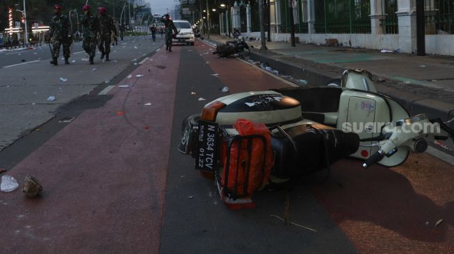 Sebuah motor Vespa yang rusak akibat terjadinya bentrokan antara petugas kepolisian dengan massa demonstran yang menolak disahkannya Undang - Undang Omnibus Law di Kawasan Gambir, Jakarta Pusat, Kamis (8/10). [Suara.com/Alfian Winanto]