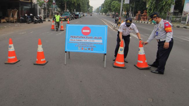 Petugas Dinas Perhubungan berjaga di ruas jalan Siliwangi, Kota Cirebon, Jawa Barat, Sabtu (10/10/2020). [ANTARA FOTO.Dedhez Anggara]