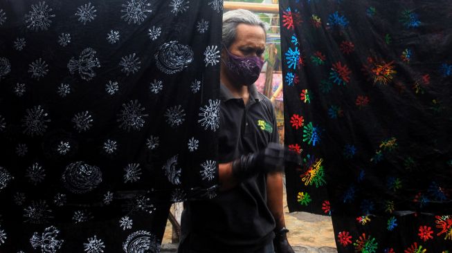 Perajin membuat batik cap dengan motif virus corona di Omah Kreatif Dongaji, Panggungharjo, Sewon, Bantul, D.I Yogyakarta, Sabtu (10/10/2020). [ANTARA FOTO/Andreas Fitri Atmoko]
