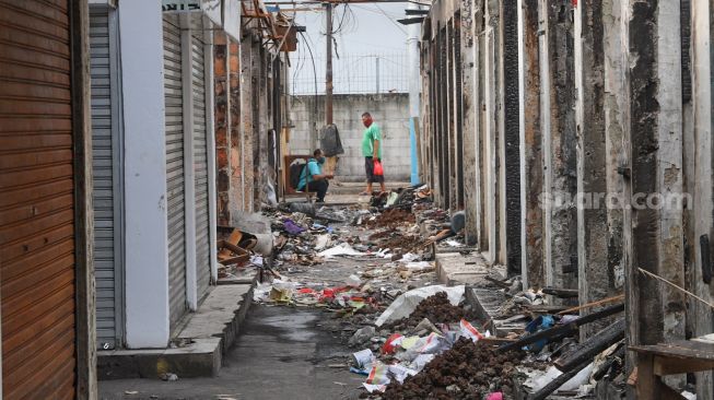 Aktivitas para pedagang diantara puing-puing toko yang habis dilalap api di Pasar Cempaka Putih, Jakarta Pusat, Sabtu (10/10). [Suara.com/Alfian Winanto]