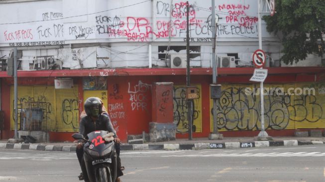 Coretan massa aksi demo tolak Omnibus Law Kamis (8/10) lalu di pertigaan Harmoni yang masih belum dihapus di kawasan Harmoni, Jakarta Pusat, Sabtu (10/10). [Suara.com/Alfian Winanto]