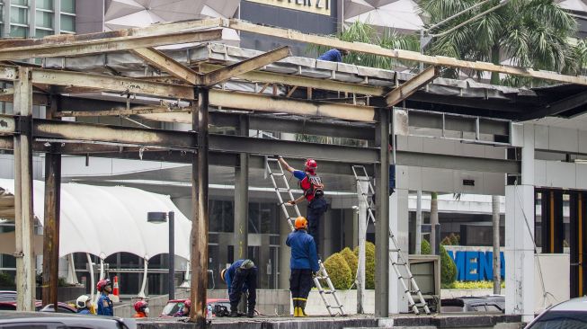 Sejumlah petugas membersihkan puing Halte TransJakarta Tosari yang rusak imbas unjuk rasa menolak pengesahan Undang-Undang Cipta Kerja di Jalan M.H. Thamrin, Jakarta, Sabtu (10/10/2020). [ANTARA FOTO/Dhemas Reviyanto]