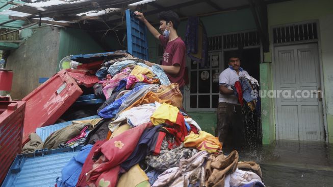 Warga melakukan evakuasi di salah satu rumah yang rusak berat akibat longsor di kawasan Ciganjur, Jagakarsa, Jakarta, Minggu (11/10/2020). [Suara.com/Angga Budhiyanto]