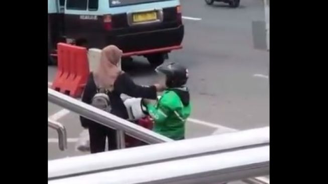 Aksi wanita mengelus pipi ojol bikin polisi terpana (Facebook)