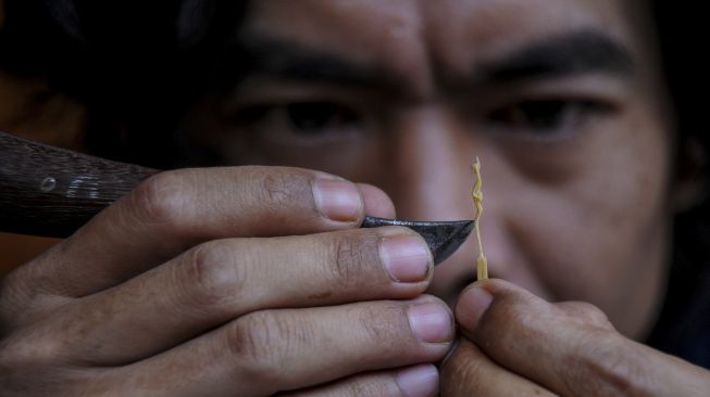 Perajin menyelesaikan produksi patung mini jenis tanimbar dengan bahan baku korek api di Jatinangor, Kabupaten Sumedang, Jawa Barat, Minggu (11/10/2020). [ANTARA FOTO/Raisan Al Farisi] 