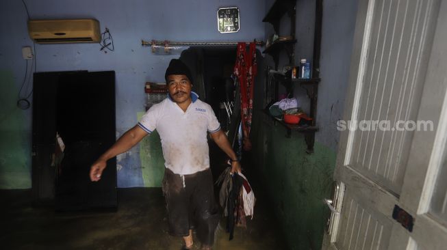 Warga melakukan evakuasi di salah satu rumah yang rusak berat akibat longsor di kawasan Ciganjur, Jagakarsa, Jakarta, Minggu (11/10/2020). [Suara.com/Angga Budhiyanto]