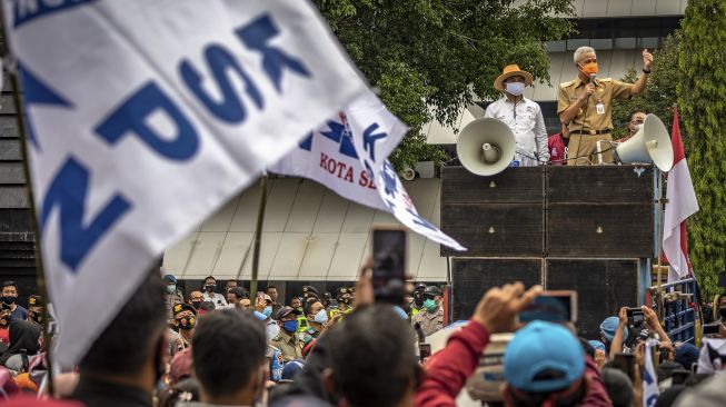 Gubernur Jateng Ganjar Pranowo (kanan) berdialog dengan massa yang tergabung dalam Konfederasi Serikat Pekerja Nasional (KSPN) Jateng dalam aksi damai menolak UU Cipta Kerja Omnibus Law di depan kompleks DPRD Jateng, Semarang, Jawa Tengah, Senin (12/10/2020). [ANTARA FOTO/Aji Styawan]