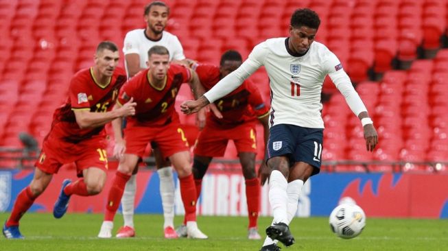 Penyerang Timnas Inggris, Marcus Rashford mengeksekusi penalti pada laga UEFA Nations League 2020/2021 kontra Belgia di Wembley, London, Senin (12/10/2020) dini hari WIB. [IAN WALTON / POOL / AFP]