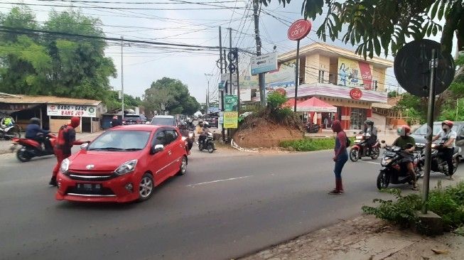 Dua juru parkir mengenakan kostum superhero Deadpool dan Spiderman saat tengah mengatur lalu lintas di  Simpang Tiga Mayabon, Cipocok Jaya, Kota Serang, Senin (12/10/2020). [Suara.com/Sofyan Hadi]